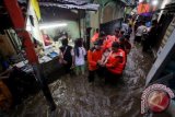 Petugas Basarnas mengevakuasi korban banjir di kawasan Kampung Pulo, Jakarta, Minggu (12/1). Banjir yang disebabkan tingginya curah hujan mengakibatkan ratusan rumah terendam dan ribuan jiwa diungsikan. ANTARA FOTO/M Agung Rajasa/wra/14.