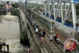 Sejumlah motor melintas di jembatan rel kereta api di kawasan Kembangan Utara, Jakbar, Senin (20/1). Kendaraan tersebut terpaksa melintas di lintasan kereta api karena sejumlah jalan terendam banjir. ANTARA FOTO/Muhammad Adimaja/wra/14.