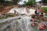 Sejumlah anak bermain di bawah lokasi tanggul Kali Laya yang jebol dan sedang dalam perbaikan di Perumahan Cimanggis Country, Depok, Jabar, Senin (13/1). Jebolnya tanggul Kali Laya menjadi daya tarik tersendiri bagi warga khususnya anak-anak untuk bermain air di sekitar lokasi jebolan tanggul meskipun hal itu dapat membahayakan keselamatan mereka. ANTARA FOTO/Indrianto Eko Suwarso/wra/14.