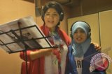 Artis senior Titiek Puspa (kiri) berduet bersama anak penyandang tuna netra Novi Indriastuti (kanan) menyanyikan lagu non profit berjudul 'Wheels To Heal' karya Natalia S. Tjahja ketika rekaman Charity Songs to the world Yayasan Maria Monique Lastwish di Jakarta, Jumat (24/1). Lagu tersebut akan dibagikan gratis kepada anak-anak lumpuh dan kurang beruntung. ANTARA/Saptono

