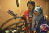 Artis senior Titiek Puspa (kiri) berduet bersama anak penyandang tuna netra Novi Indriastuti (kanan) menyanyikan lagu non profit berjudul 'Wheels To Heal' karya Natalia S. Tjahja ketika rekaman Charity Songs to the world Yayasan Maria Monique Lastwish di Jakarta, Jumat (24/1). Lagu tersebut akan dibagikan gratis kepada anak-anak lumpuh dan kurang beruntung. ANTARA/Saptono