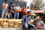 Satuan narkoba Polres Pidie menangkap pembawa ratusan bal ganja kering siap edar di lintasan jalan negara, Pidie, Aceh, Sabtu (4/1). Polres Pidie berhasil menyita 610 kg ganja kering yang hendak diselundupkan ke luar Aceh, satu mobil truk dan menangkap dua tersangka. ANTARA FOTO/Ampelsa/nym/2014.