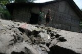       Kediri (Antara Jatim) - Dua orang anak bermain di halaman rumah mereka yang penuh material pasir akibat lahar dingin Gunung Kelud, di kawasan pemukiman pinggir sungai Konto, Pare, Kediri, Jawa Timur, Kamis (20/2). Badan Nasional Penangulangan Bencana (BNPB) mengingatkan kepada warga yang tingal di pingiran sungai konto agar lebih hati-hati menginggat ancaman luapan aliran material lahar dingin akan terjadi sewaktu-waktu. FOTO Rudi Mulya/14/Chan.