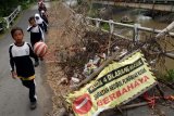 PASURUAN (Antara Jatim) - Sejumlah siswa dan guru melintas di jembatan sedodol yang mengalami penurunan pondasi penyangga tengah jembatan, di Desa Pelinggisan, Kec. Kraton, Pasuruan, Jatim, Selasa (11/2). Kemiringan jembatan sedodol yang semakin parah akan mengakibatkan sewaktu - waktu bisa runtuh dan menelan korban jiwa. FOTO/Adhitya Hendra/EI/14.