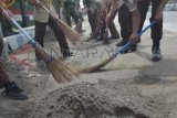 Madiun (Antara Jatim) - Sejumlah warga melakukan kerja bakti massal di kawasan Mangunharjo, Kota Madiun, Minggu (16/2). Ribuan warga dibantu dengan anggota TNI, Polri, Pramuka dan pecinta alam melakukan kerja bakti massal untuk membersihkan lingkungan mereka dari abu vulkanik akibat letusan Gunung Kelud. FOTO Fikri Yusuf/14/Oka.