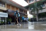 Madiun (Antara Jatim) - Karyawan Pemkab membersihkan material vulkanik Gunung Kelud di lingkungan Kantor Pemkab Madiun, Selasa (18/2). Seluruh pegawai Pemkab melakukan kerja bakti massal pada hari tersebut untuk membersihkan lingkungan kantor masing-masing dari material vulkanik akibat letusan Gunung Kelud. FOTO Siswowidodo/14/Oka.