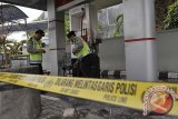 Dua polisi memeriksa mesin stasiun pengisian bahan bakar umum (SPBU) yang terbakar di Denpasar, Bali, Rabu (5/2).  Kebakaran yang dipicu oleh percikan api dari sepeda motor konsumen tersebut menyebabkan dua orang luka bakar. FOTO ANTARA/Nyoman Budhiana/nym/2014.