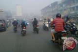 Kabut asap di Pontianak, Rabu (5/2) semakin tebal dan berbau tajam, sehingga membuat jarak pandang semakin dekat dan membuat risiko peningkatan penyakit saluran pernafasan (Ispa). Bagi warga yang mengendarai sepeda motor, selain menggunakan masker, juga harus berhati-hati denagn jarak pandang yang terbatsa itu. (Foto Atara Kalbar / Andilala)