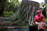 Warga mengambil air bersih yang dialirkan dari Gunung Mandalawangi dengan menggumakan selang di Kampung Sekoler, Baros, Kabupten Serang, Banten, Kamis (20/1). Jaringan distribusi air itu dibiayai secara gotong royong dan mereka menginginkan Pemda setempat untuk membuat jaringan pipa yang permanen agar kebocoran dapat dikurangi. ANTARA FOTO/Asep Fathulrahman/nym/2014.