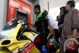 Wakil Direktur Utama BNI, Felia Salim (kanan) dan Plh. Walikota Banda Aceh Hj Illiza Sa'aduddin Jamal (kedua kanan) menyaksikan pengedara sepeda motor bertransaksi di Anjungan Tunai Mandiri (ATM) khusus untuk pengendara sepeda motor yang barus diresmikan di Jalan T. Nyak Arif, Banda Aceh, Jumat (21/2). Sebagai upaya memberikan pelayanan terbaik kepada nasabah, BNI memiliki 11 ATM untuk pengendara sepeda motor di seluruh Indonesia. ANTARA FOTO/Irwansyah Putra