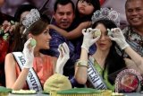 Miss Universe 2013, Gabriella Isler (kiri) bersama Putri Indonesia 2014, Elvira Devinamira (kanan) menunjukkan kue Bakpia buatannya saat mengunjungi sentra pembuatan Bakpia, di Yogyakarta, Jumat (31/1). Kegiatan membuat Bakpia yang merupakan makanan khas Yogyakarta tersebut merupakan rangkaian kunjungan yang dilakukan oleh Miss Universe 2013 dan Putri Indonesia ke 2014 ke Yogyakarta. ANTARA FOTO/Noveradika