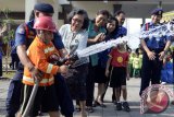 Seorang murid Taman Kanak-Kanak (TK) mendengarkan penjelasan tentang peralatan yang digunakan oleh petugas untuk memadamkan api, saat berkunjung ke Dinas Pemadam Kebakaran Kabupaten Badung, Bali, Jumat (28/2). Dalam pengenalan tentang peralatan dan tugas pemadam kebakaran tersebut, para siswa juga mendapatkan penjelasan tentang bahaya yang mengancam jika mereka bermain api. FOTO ANTARA/Wira Suryantala/wra/14. 