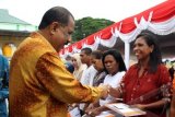 Wali Kota Ambon Richard Louhenapessy (kiri) menyerahkan bantuan Program Keluarga Harapan (PKH) kepada perwakilan rumah tangga sasaran yang dipusatkan di kawasan Kapahaha, Ambon, Maluku, Kamis (6/3). Sebanyak 1.424 rumah tangga sasaran menerima bantuan dari Kementerian Sosial. ANTARAFOTO/Izaac Mulyawan/ss/Spt/14