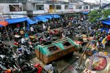 Pedagang kaki lima berjualan dekat bak sampah yang ditempatkan ditengah keramaian pengunjung di Pusat Pasar Peunayung, Banda Aceh, Sabtu (22/3). Kondisi pasar tradisional tidk hanya semrraut akibat parkir kendaraan menutupi badan jalan, namun juga tidak sehat karena penempatan bak sampah yang menyebarkan bau busuk rawan penularan penyakit.ANTARAACEH.COM/Ampelsa/14