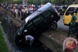 Petugas berupaya mengevakuasi satu unit mobil Toyota Inova dengan nomor polisi BL 309 J yang masuk ke parit akibat kecelakaan lalu lintas di jalan T Panglima Nyak Makam, Banda Aceh, Minggu (23/3). Angka kecelakaan di jalan raya yang berakibat hilangnya nyawa di seluruh Indonesia pada 2013 mencapai 25.157 kasus, khusus di Aceh 672 kasus. ANTARA FOTO/Irwansyah Putra/ss/pd/14.