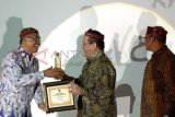Surabaya (Antara Jatim) - Ketua PWI Jatim, Akhmad Munir. (kiri) memberikan penghargaan 
