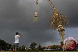 Seorang warga memotret saat awan hujan melintasi Kota Denpasar, Bali, Senin (3/3). Badan Meteorologi dan Geofisika memperkirakan, di Bali berpotensi terjadinya cuaca tidak menentu yaitu hujan yang disertai kilat/petir dan angin kencang berdurasi singkat dalam beberapa hari ke depan. ANTARA FOTO/Nyoman Budhiana/i018/2014.