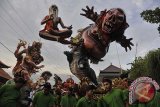 Sejumlah pemuda mengarak Ogoh-Ogoh atau boneka raksasa yang melambangkan Bhuta Kala (sifat-sifat buruk) dalam Festival Ogoh-Ogoh 2014 menjelang Hari Raya Nyepi Tahun Saka 1936 di Desa Tegallalang, Gianyar, Bali, Sabtu (29/3). Umat Hindu menggelar parade Ogoh-Ogoh berkeliling kampung untuk menetralisir kekuatan negatif dan sifat buruk agar Hari Raya Nyepi dapat dilaksanakan dengan penuh keheningan serta tanpa gangguan apapun. ANTARA FOTO/Nyoman Budhiana/nym/2014.