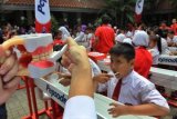 Ratusan siswa melakukan sikat gigi bersama saat peringatan Hari Kesehatan Mulut Sedunia (World Oral Health Day) 2014 di SD Negeri Tomang 01 Pagi, Jakarta, Kamis (20/3). Kegiatan sikat gigi bersama yang diselenggarakan Pepsodent secara serentak di 117 kota di seluruh Indonesia ini diikuti sekitar 20.000 siswa. ANTARA FOTO/Dhoni Setiawan/Koz/ama/14.