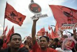 Sejumlah simpatisan mengibarkan bendera dan atribut partai dalam kampanye PDI-P di Lapangan Kapten Surem, Kabupaten Badung, Bali, Sabtu (22/3). Kampanye yang dihadiri ribuan simpatisan itu menghadirkan juru kampanye nasional (Jurkamnas), Megawati Soekarnoputri, Rano Karno, Puan Maharani dan sejumlah kader serta calon legislatif (Caleg) PDI-P Bali. ANTARA FOTO/Nyoman Budhiana/nym/2014.