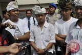 Polisi mengawal 3 warga Kelurahan Sidakarya Denpasar, Made Adi Jayanatha (kiri), Kadek Mudana (tengah) dan Wayan Saniyasa (kedua kanan) saat mereka dengan sukarela datang untuk diinterogasi kepolisian terkait kasus unjukrasa berisi pengancaman terhadap Gubernur Bali, di Mapolda Bali, Senin (3/3). Unjuk rasa tersebut berlangsung 26 Pebruari lalu untuk menolak rencana reklamasi Teluk Benoa namun dalam spanduk yang berisi cap jempol darah itu dinilai mengandung ancaman terhadap nyawa Gubernur Bali, Made Mangku Pastika. ANTARA FOTO/Nyoman Budhiana/i018/2014.