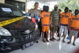 Madiun (Antara Jatim) - Kapolres Madiun, AKBP Rahmat Setiadi (kanan) menunjukkan empat tersangka dan barang bukti perampasan mobil di Polres Madiun, Jumat (28/2). Tersangka tersebut mengaku sebagai debt collector sebuah lembaga leasing dan memaksa merampas mobil yang melintas di wilayah Wungu, Madiun. (FOTO Fikri Yusuf/14/edy)