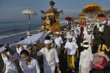 Sejumlah Umat Hindu membawa benda-benda sakral ke laut saat upacara Melasti menjelang pelaksanaan Hari Raya Nyepi Tahun Saka 1936, di Pantai Purnama, Gianyar, Bali, Jumat (28/3). Ritual Melasti tersebut bermakna untuk penyucian diri dan alam agar Hari Raya Nyepi pada 31 Maret mendatang dapat dilaksanakan dengan hening. ANTARA FOTO/Nyoman Budhiana/nym/2014.