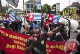 Sejumlah anggota Aliansi Mahasiswa Papua dengan atribut bendera Bintang Kejora melakukan aksi unjuk rasa di kawasan Jalan Jendral Sudirman, Yogyakarta, Kamis (13/3). Dalam aksinya mereka menuntut kepada PBB, Amerika dan Indonesia untuk memberikan kebebasan dan hak menentukan nasib sendiri bagi rakyat Papua sebagai solusi demokratis sesuai hukum yang berlaku. ANTARA FOTO/Sigid Kurniawan/wdy/14