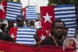 Sejumlah anggota Aliansi Mahasiswa Papua dengan atribut bendera Bintang Kejora melakukan aksi unjuk rasa di kawasan Jalan Jendral Sudirman, Yogyakarta, Kamis (13/3). Dalam aksinya mereka menuntut kepada PBB, Amerika dan Indonesia untuk memberikan kebebasan dan hak menentukan nasib sendiri bagi rakyat Papua sebagai solusi demokratis sesuai hukum yang berlaku. ANTARA FOTO/Sigid Kurniawan/wdy/14