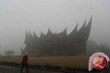 Sejumlah wisatawan lokal menggunakan masker saat berada di obyek wisata Istana Pagaruyung yang di selimuti kabut asap, Kabupaten Tanah Datar, Sumbar, Sabtu (15/3). Pengelola obyek wisata Istana Pagaruyung mengatakan kunjungan wisatawan menurun dratis hingga mencapai 50 persen akibat kabut asap kiriman dari provinsi Riau, yang terjadi pada beberapa minggu terakhir ini. (ANTARA FOTO/Muhammad Arif Pribadi/wdy/14)