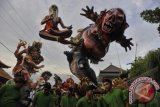 Sejumlah pemuda mengarak 'Ogoh-Ogoh' atau boneka raksasa yang melambangkan Bhuta Kala (sifat-sifat buruk) dalam Festival Ogoh-Ogoh 2014 menjelang Hari Raya Nyepi Tahun Saka 1936 di Desa Tegallalang, Gianyar, Bali, Sabtu (29/3). Umat Hindu menggelar parade Ogoh-Ogoh berkeliling kampung untuk menetralisir kekuatan negatif dan sifat buruk agar Hari Raya Nyepi dapat dilaksanakan dengan penuh keheningan serta tanpa gangguan apapun. ANTARA FOTO/Nyoman Budhiana