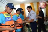 Direktur LLASDP Direktorat Perhubungan Darat Sudirman Hambali   memasangkan secara simbolis rompi pelampung  keselamatan pada acara sosialisasi kelaikan sarana angkutan sungai dan danau (Foto Humas Pemkot / Jimmy Ibrahim).