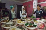 Seorang pedagang kue Kek Lapis, dari Kuching Sarawak, menunjukkan berbagai jenis kue contoh untuk dikonsumsi pengunjung saat datang ke Kedai Kue Dayang Salhah, di Kota Kuching, Sarawak. (Foto Antara Kalbar/ Nurul Hayat).