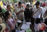 Seorang warga protes kepada petugas KPPS dan KPU Denpasar terkait kekeliruan pemanggilan pemilih karena kesamaan nama dalam pemungutan suara ulang Pemilu Legislatif 2014 di Lingkungan Wanasari, Denpasar, Minggu (20/4). KPU Denpasar melakukan pemungutan suara ulang di 2 TPS dengan daftar pemilih tetap sebanyak 720 orang, karena adanya dugaan sejumlah pemilih menggunakan hak pilihnya dua kali di kedua TPS tersebut pada pemungutan suara Pemilu Legislatif 9 April lalu. ANTARA FOTO/Nyoman Budhiana/nym/2014.