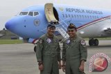 Pilot Pesawat Kepresidenan Republik Indonesia, Letkol Pnb. Ali Gusman (kanan) dan Letkol Pnb. Firman Wirayuda (kiri) berfoto bersama usai mengawaki pesawat tersebut mendarat perdana di Pangkalan Udara TNI AU Halim Perdanakusuma, Jakarta, Kamis (10/4). Pesawat RI 1 jenis Boeing Bussiness Jet 2 (BBJ2) varian dari Boeing 737 seri 800 yang memiliki spesifikasi dan desain interior khusus untuk penerbangan VVIP dan baru pertama kali dimiliki oleh Indonesia tersebut dibeli pemerintah seharga US$89,6 juta atau sekitar Rp847 miliar. ANTARA FOTO/Widodo S. Jusuf/wdy/14.