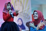 Penyanyi Dewi Sandra menyaksikan penggemarnya bernyanyi pada acara hijab fashion show di Mega Tred Center (MTC), Manado, Sulawesi Utara, Minggu (13/4). Dalam kesempatan itu Dewi Sandra juga memberikan motivasi kepada sejumlah hijaber Manado. ANTARA FOTO/Fiqman Sunandar