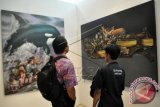 Pengunjung memperhatikan lukisan pada pameran seni rupa bertajuk The Power Of Culture di Limanjawi Art House Tingal Kulon, Wanurejo, Borobudur, Magelang, Jateng, Minggu (20/4). Pameran tujuh perupa dari Yogyakarta tersebut dalam rangkaian Magelang Art Event (MAE) 2014 yang mengusung tema "Greng". FOTO ANTARA/Anis Efizudin