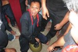 Seorang tokoh adat negeri Ullath, Saparua, Agus Latul melakukan ritual Tampayang Goyang (menggoyang tempayan). Tempayan tersebut berisi sopi, minuman khas orang Maluku, yang tidak pernah habis untuk diberikan kepada seluruh warga negeri dan pendatang yang menyaksikan prosesi adat Tutup Baileo pada Jumat (9/5). Foto John Nikita Sahusilawane.