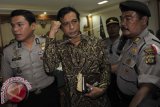 Mantan Direktur Utama PT Penata Sarana Bali, Chris Sridana (tengah) digiring polisi seusai mengikuti sidang pengadilan tindak pidana korupsi (Tipikor) retribusi parkir Bandara Ngurah Rai di Pengadilan Tipikor Denpasar, Bali, Senin (5/5). Majelis hakim menjatuhkan vonis 15 tahun penjara bagi terdakwa karena dinilai bersalah turut serta dalam melakukan tindak pidana korupsi pendapatan parkir Bandara Ngurah Rai periode November 2008- Desember 2011 yang merugikan negara sekitar Rp28,12 miliar. FOTO ANTARA/Nyoman Budhiana/wdy/14.