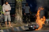 Sejumlah warga melihaat kondisi motor bernopol N 5713 CB yang terbakar di Jalan Raya Panglima Sudirman, Malang, Jatim, Kamis (22/5). Terbakarnya motor tersebut disebabkan adanya kebocoran pada saluran bahan bakar yang mengakibatkan hampir sebagian motor terbakar dalam peristiwa tersebut tidak ada korbaan jiwa.ANTARA FOTO/Adhitya Hendra/14