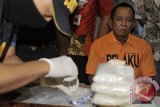 Petugas Bea Cukai menguji sampel sabu-sabu yang dibawa Arsain Bin Anwar (kanan) saat gelar kasus penyelundupan narkoba di Kantor Bea Cukai Bandara Ngurah Rai, Denpasar, Bali, Sabtu (17/5). Tersangka yang juga tenaga kerja Indonesia (TKI) asal Madura tersebut ditangkap karena membawa 2,5 Kg sabu-sabu yang disembunyikan dalam dinding tas saat tiba di Bandara Ngurah Rai setelah menempuh penerbangan dari Kualalumpur, Malaysia, Jumat (16/5). ANTARA FOTO/Nyoman Budhiana/nym/2014.