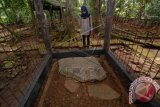 Pengunjung mengamati sebuah prasasti telapak kaki dan tangan Maha Prabu Niskala Wastu Kancana (Raja Sunda Galuh) di kawasan Wisata Sejarah Asatana Gede, Kawali, Kabupaten Ciamis, Jawa Barat, Kamis (15/5). Dalam prasasti tersebut terdapat juga 45 kotak beserta puluhan titik-titik lobang yang berfungsi sebagai media palintangan (kalender panata mangsa). ANTARA FOTO/Adeng Bustomi/wdy/14