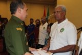 Gubernur Maluku Said Assagaff (kiri) menyerahkan penghargaan pelatih tinju yang berdedikasi bagi pengembangan tinju di Maluku kepada pelatih Wiem Gomies (kanan) saat pelantikan Pengprov Pertina Maluku di Ambon, Maluku, Senin (23/6). Wiem Gomies merupakan legenda tinju amatir Indonesia. Prestasi Wiem Gomies diawali dengan meraih medali emas kelas 71 kg PON VII/1969 di Surabaya. Setelah itu, ia meraih dua medali emas asian Games, satu medali emas kejuaraan Asia serta sederet prestasi nasional dan ASEAN. Wiem Gomies berhenti bertinju pada tahun 1981 dan beralih menjadi pelatih. ANTARA FOTO/Izaac Mulyawan/Asf/nz/14.
