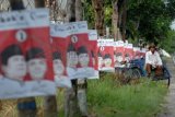 Seorang abang becak, menunggu penumpang, di dekat poster pasangan Capres Cawapres, di Jalan Raya Pamekasan-Sumenep, Pamekasan, Jatim, Kamis (12/6).  Menjelang Pemilihan Presiden, 9 Juli yang akan datang, sejumlah ruas jalan di kabupaten itu, dipenuhi alat peraga pasangan Capres-Cawapres. Bahkan beberapa diantaranya dipasang pada fasilitas publik. FOTO Saiful Bahri/14/Chan.
