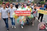 Sejumlah aktivis dari Paguyuban Cak-Ning Suroboyo menggelar aksi simpatik 'Diet Tas Kresek' saat Car Free Day (CFD) di Taman Bungkul Surabaya, Jatim, Minggu (8/6). Aksi yang diikuti pungut sampah tas kresek (plastik) tersebut untuk mengajak masyarakat agar berhenti memakai tas plastik karena proses terurainya di alam membutuhkan waktu hingga 100 tahun. ANTARA FOTO/Eric Ireng/wdy/14
