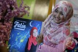 Penyanyi Juara X Factor 2013 Fatin Shidiqia Lubis memperlihatkan album religi islam bertajuk 12 Lagu Islami Terbaik Fatin And Friends dan buku hijab Fatin saat menghadiri peluncurannya di Jakarta, Selasa (24/6). Dalam menyambut Ramadan 1435 H, Fatin meluncurkan album religi terbarunya dan buku keduanya tentang berbusana hijab ala Fatin . ANTARA FOTO/Teresia May/ed/mes/14