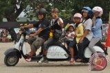 Sejumlah pengunjung menaiki sepeda motor vespa yang telah dimodifikasi pada pameran 'Celebes Scooter Party ' di Palu, Sulawesi Tengah, Sabtu (7/6). Celebes Scooter Party yang digelar 7 -8 Juni 2014 diikuti ribuan pecinta motor skuter dari seluruh Indonesia dan bertujuan sebagai ajang silaturahmi para pecinta sepeda motor antik. ANTARA FOTO/Mohamad Hamzah/wdy/14.