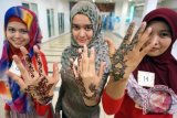 Tiga model menunjukkan karya seni Henna yang ada di tangan, usai Lomba Seni Henna di BG Junction Surabaya, Sabtu (14/6). Lomba dalam rangkaian Henna Art Festival 2014 yang diikuti 50 seniman Henna se Jatim tersebut, bertujuan untuk lebih mengenalkan seni Henna khas Timur Tengah di kalangan muslimah dan warga Surabaya. ANTARA FOTO/Eric Ireng/ss/nz/14