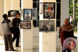 Banjarmasin, 21/6 - Warga menyaksikan puluhan foto jurnalistik karya Pewarta Foto Kalimantan Selatan di gedung Menara Pandang Sungai Martapura Banjarmasin, Sabtu (21/6). Pewarta Foto Kalimantan Selatan menggelar lelang dan pameran foto jurnalistik dalam rangka puncak peringatan Hari Pers Daerah 2014. Foto Antaranews Kalsel/Herry Murdy Hermawan