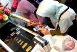 Beberapa calon pelanggan memperhatikan cetakan emas batangan berbagai ukuran di gerai Butik Emas Banjarmasin, Senin (23/6). Gerai Butik Emas Bamjarmasin menawarkan produk batangan emas, perak dinar dan dirham, disamping produk olahan berbahan emas seperti pin, lencana, tanda penghargaan hingga koin bercetak wajah. Foto Antaranews Kalsel/Herry Murdy Hermawan